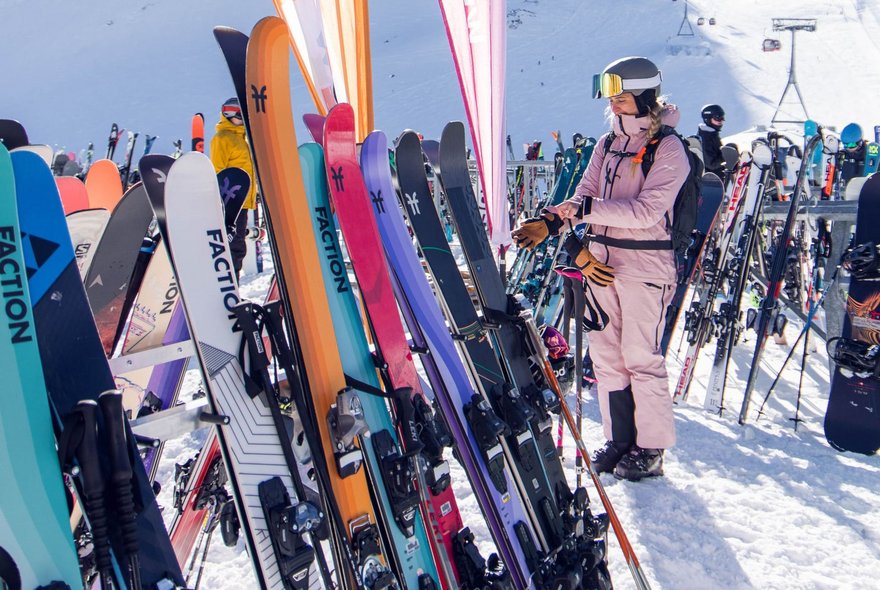 Bunte Ski stehen im Skiständer auf Festivalgelände