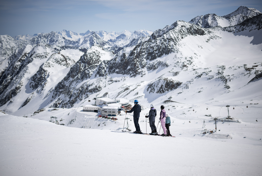 Skifahrfamilie schaut zur Bergstation Eisgrat hinunter