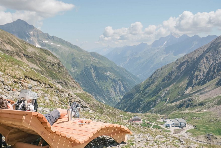 Wanderer macht auf einer Panoramaliege Pause
